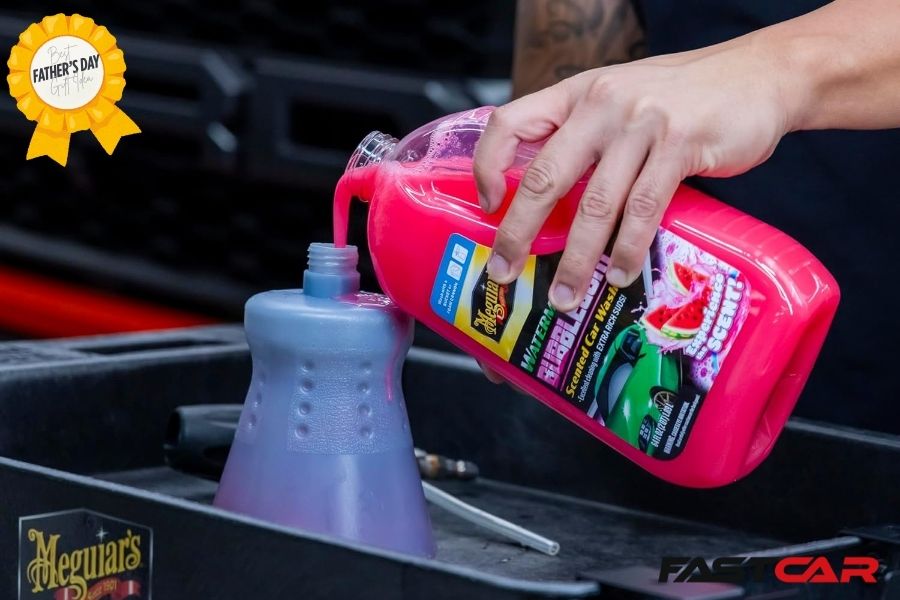 Hand pourinhg car shampoo into a snow foam gun